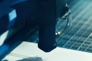 Laser Cutting Close-up of a laser cutting detailed patterns into a plastic sheet during precision fabrication.
